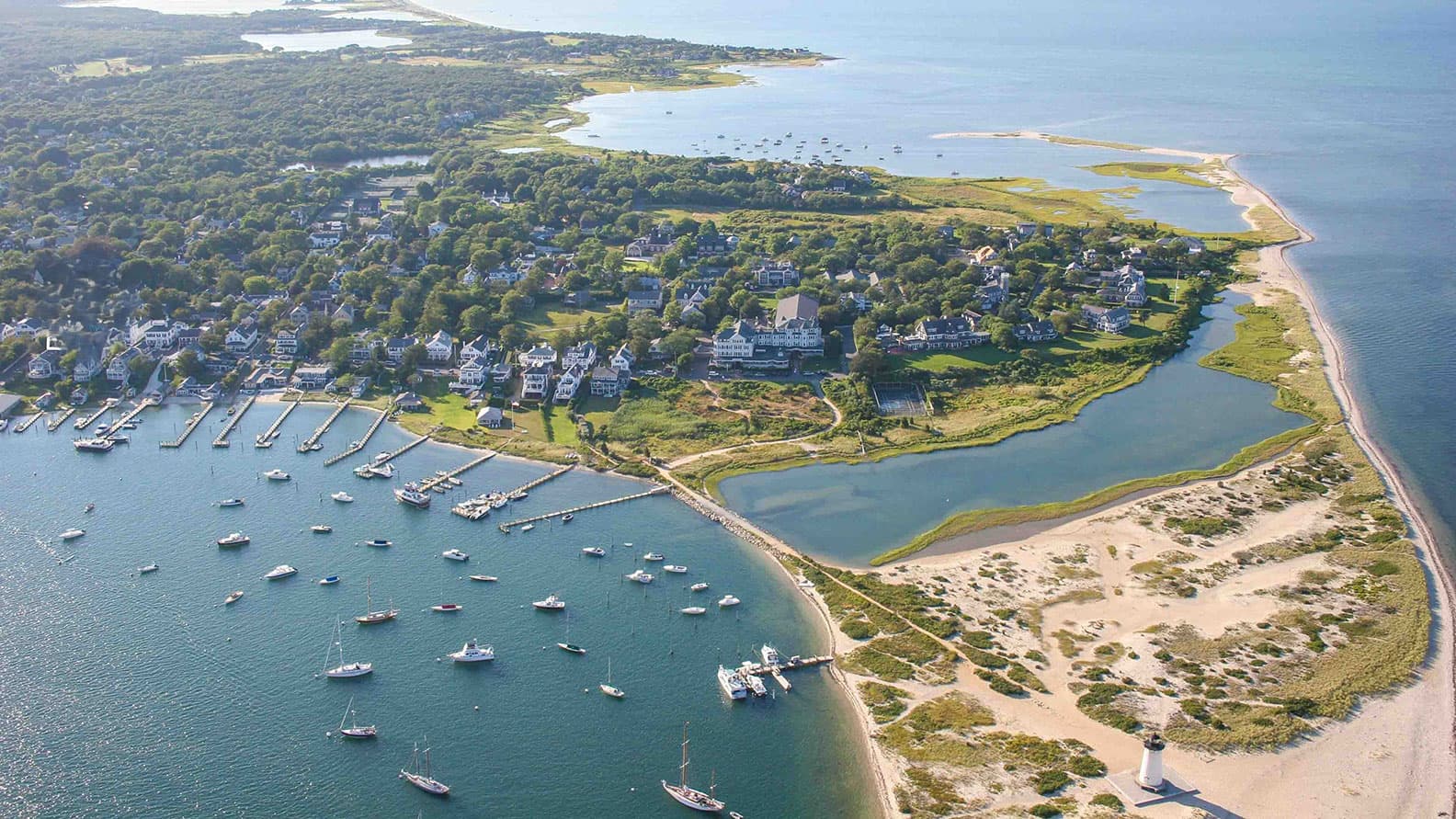 Aerial view of Edgartown Harbor, its moored boats and the Edgartown Lighthouse on Martha’s Vineyard